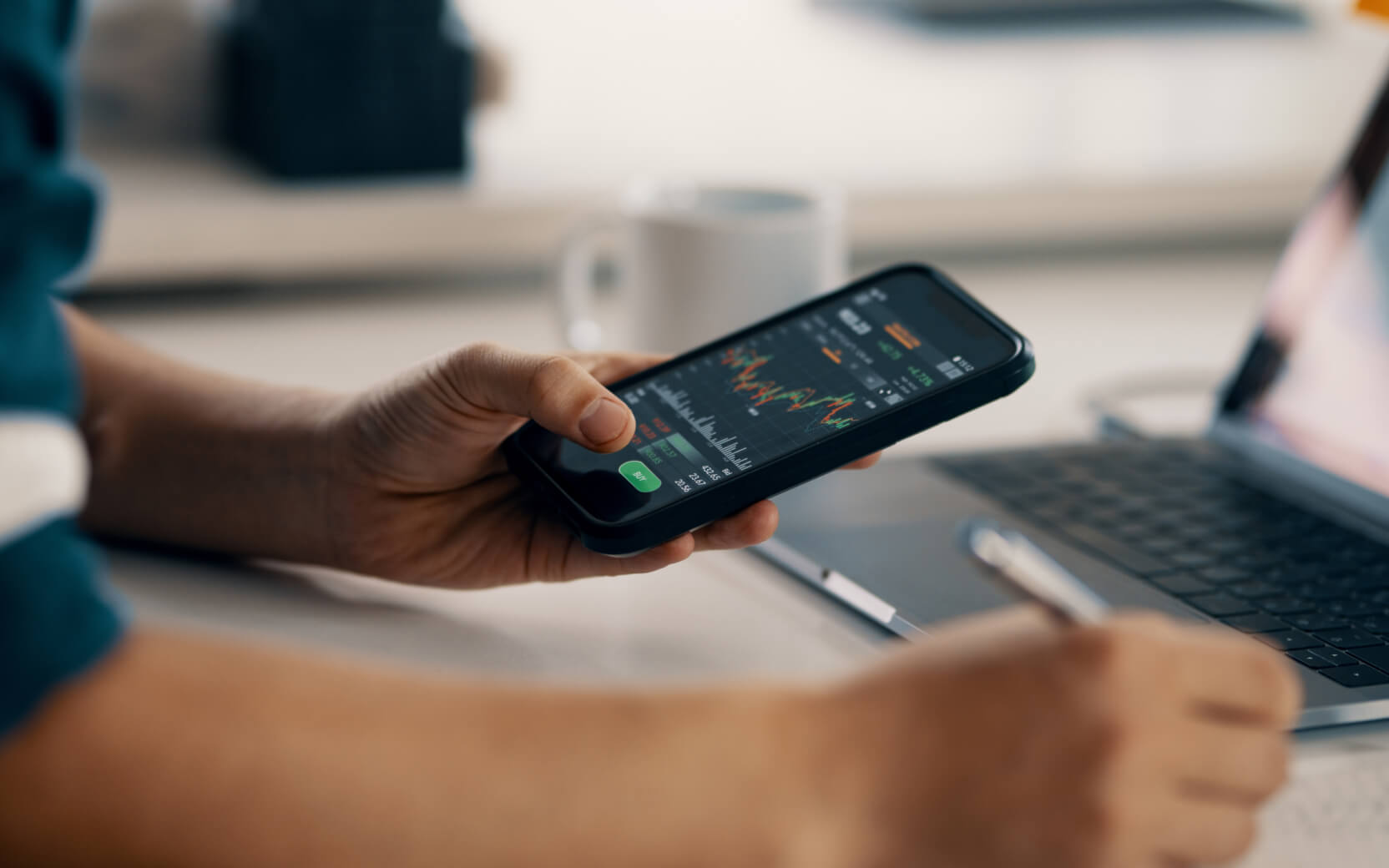 Man looks at stocks graph on smart phone